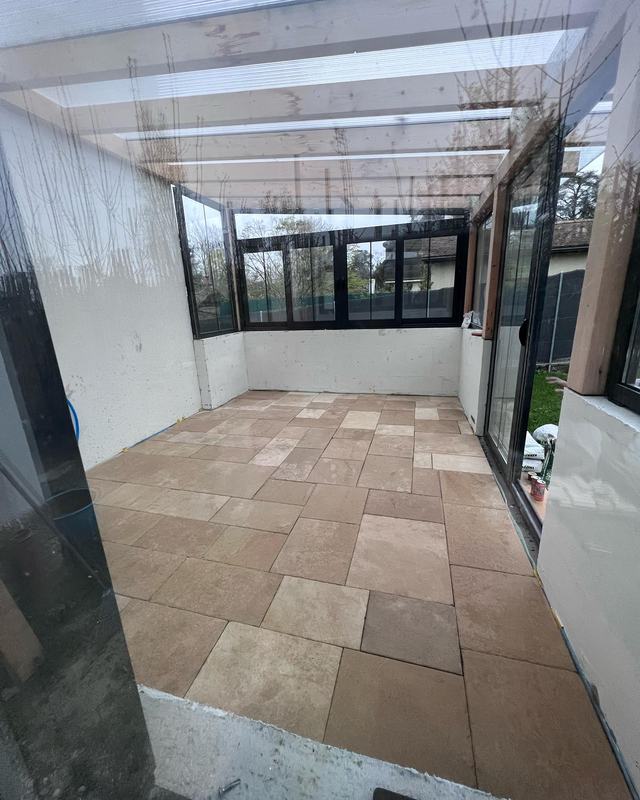 Dalles de pierre naturelle beige dans une véranda