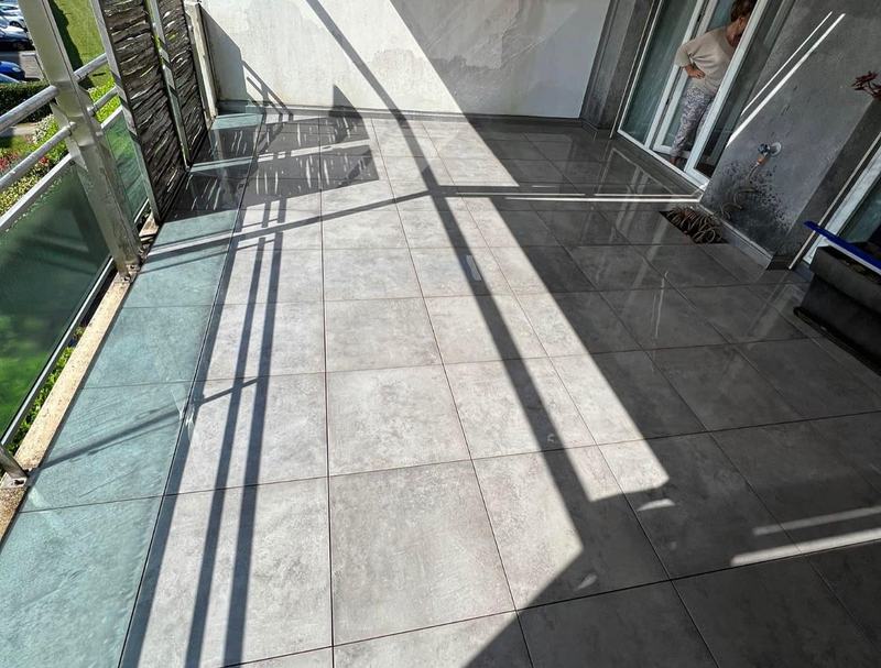 Terrasse terminée en dalles grises grand format, au soleil